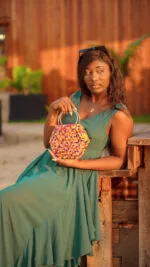 Mannequin tenant à la main le sac à main hexagonal perlé multicolore à anse anneau doré
