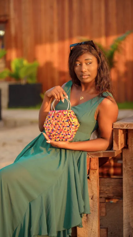 Mannequin tenant à la main le sac à main hexagonal perlé multicolore à anse anneau doré
