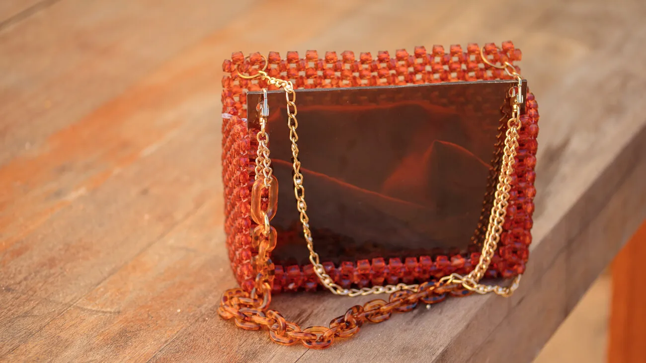 Gros plan sur la façade en acrylique ambre brillant et la double chaîne du sac à main