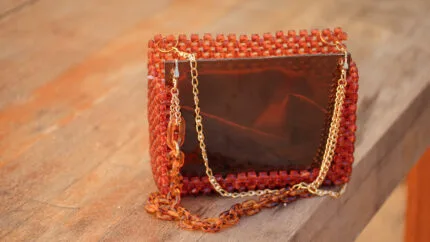 Gros plan sur la façade en acrylique ambre brillant et la double chaîne du sac à main
