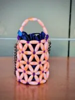 Vue de face du mini sac perlé rose pêche et violet à motif floral, doublure satin bleu marine